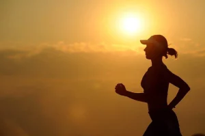 Frau joggt während dem Sonnenuntergang