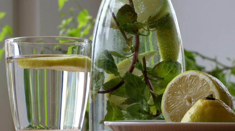 Basische Getränke: Zitronenwasser mit Minze in Karaffe und Glas