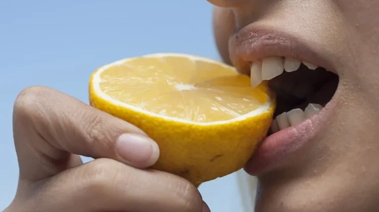 Mann beißt auf Zitrone